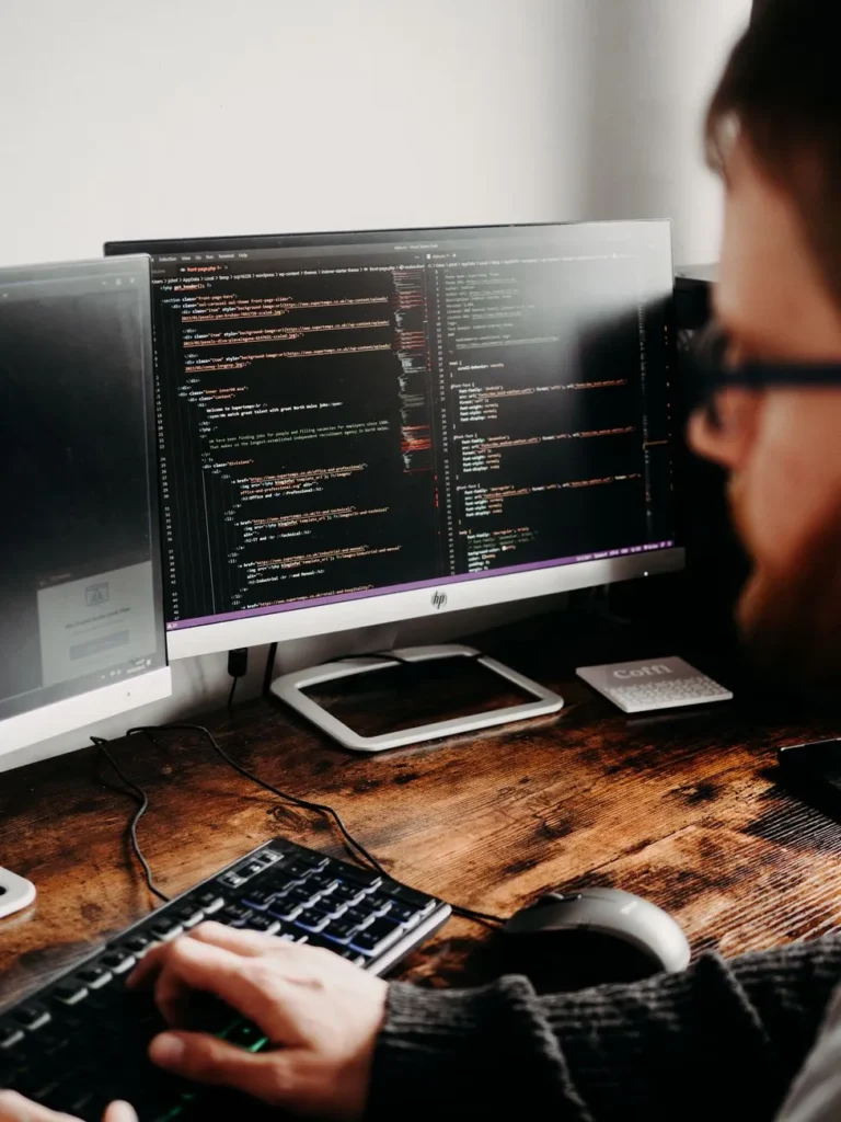 Developer working on website code at a desktop monitor