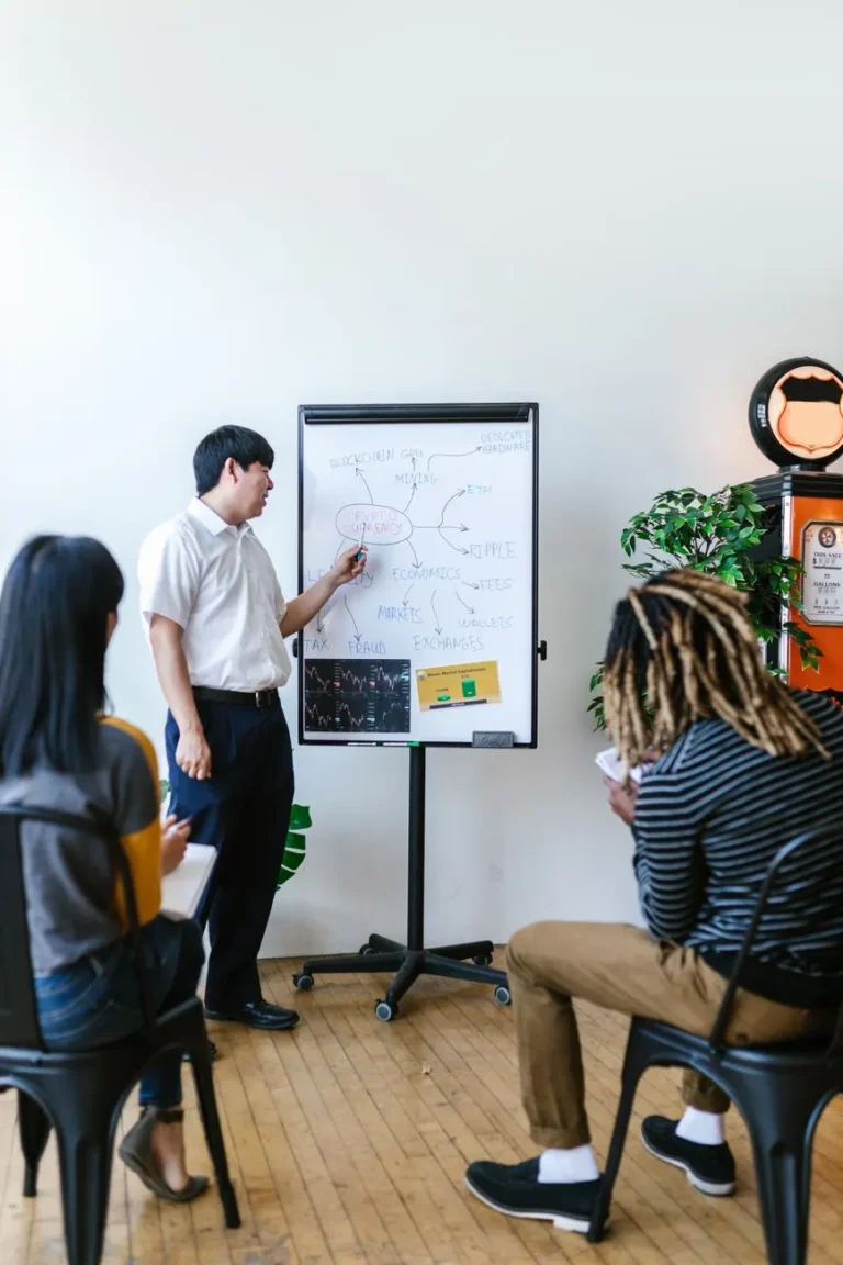 Engineer sketching a system diagram on a whiteboard for the team